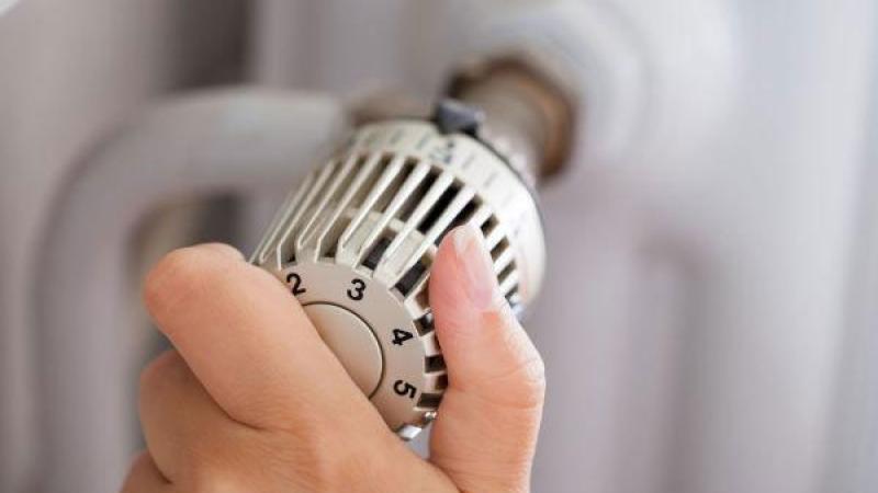 Close-up van hand die aan radiatorknop draait
