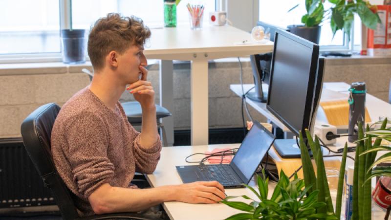 Jongeman achter laptop