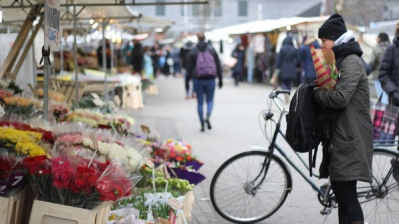 Vrouw staat voor bloemenkraam