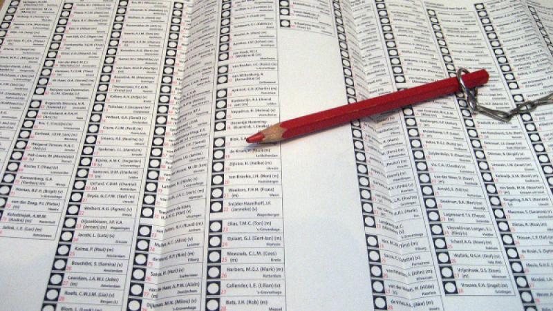 rood potlood aan ketting ligt op stembiljet