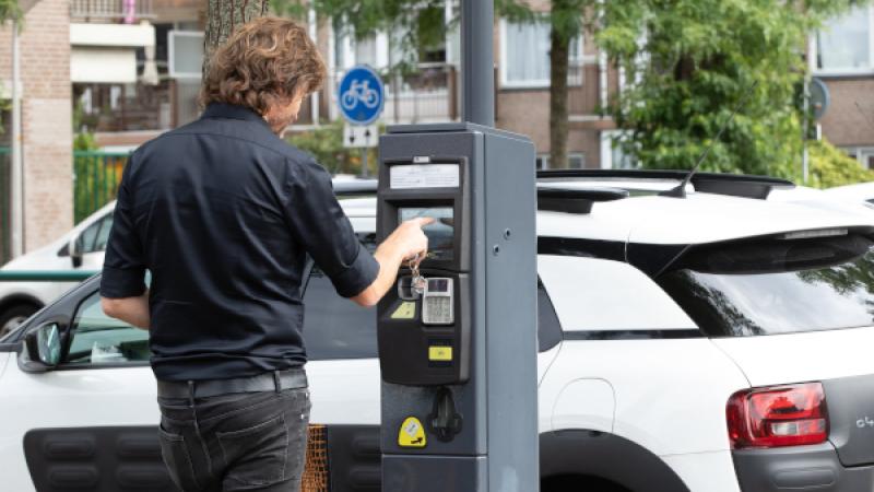 Man toetst parkeermeter in