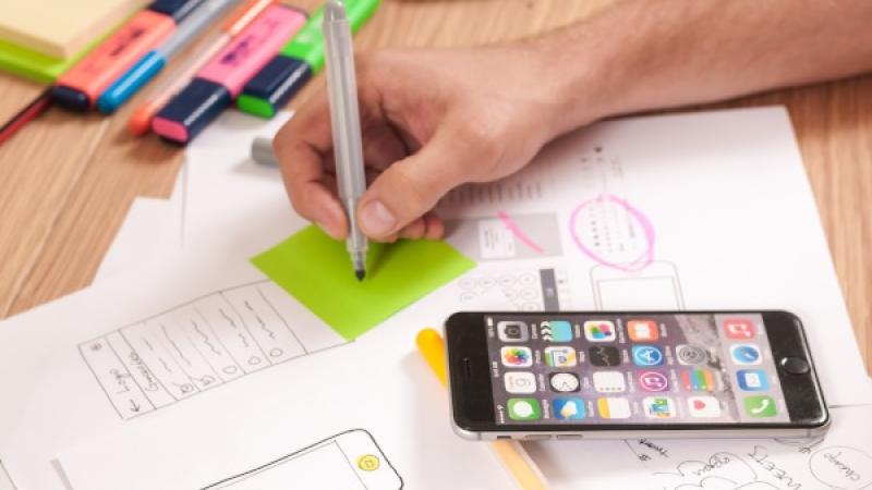 foto van bureau met markerpennen, papieren en mobiel