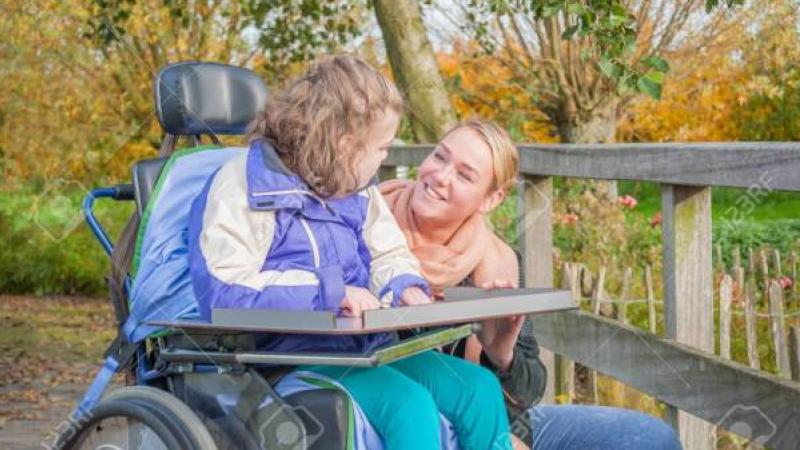 meisje in rolstoel in gesprek met vrouw