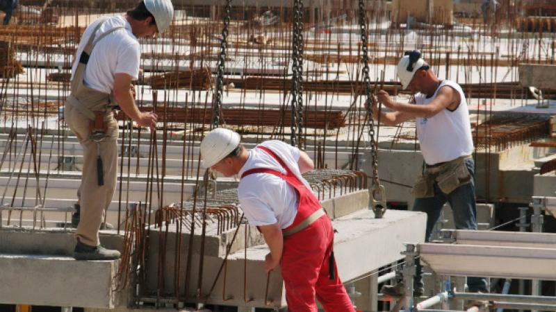 Drie bouwvakkers aan het werk op een bouwplaats