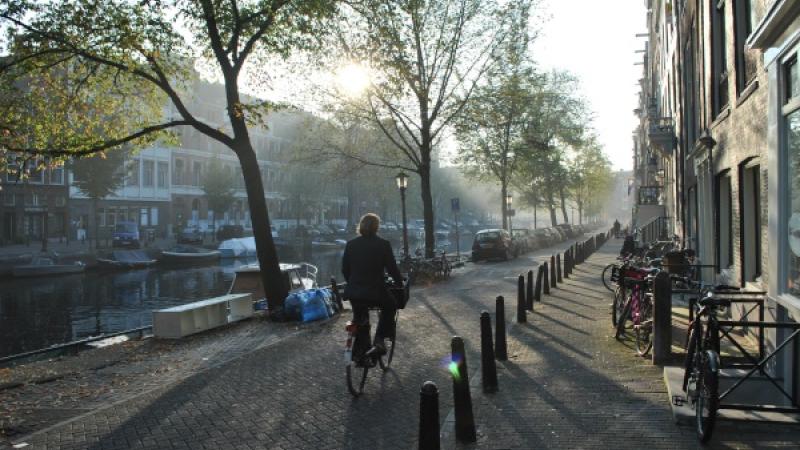 Iemand fiets door de straat langs de gracht
