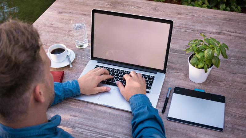 Man aan het werk achter laptop