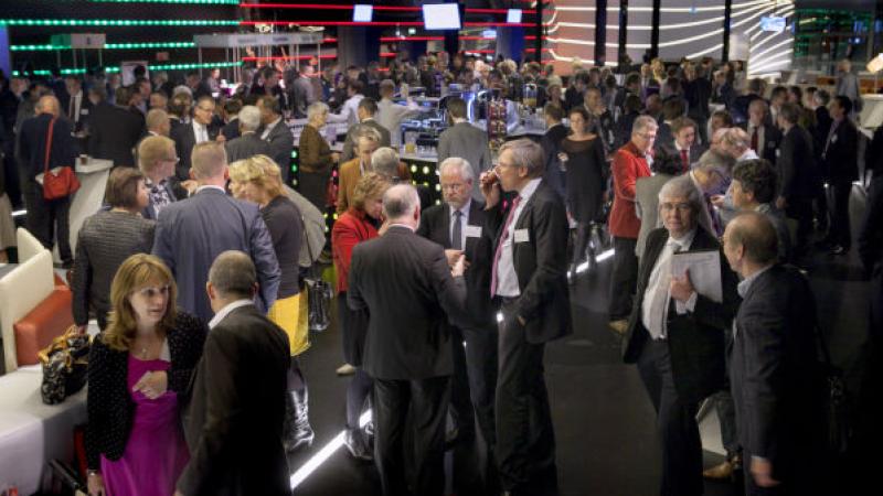deelnemers aan een VNG-bijeenkomst in de foyer tijdens een pauze