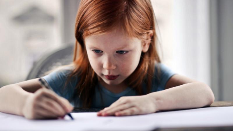 Jong meisje schrijft op papier