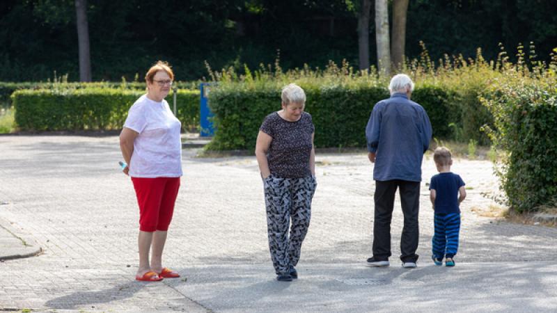 vluchtelingen (twee vrouwen, een man en een kind) wandelen op het terrein van een opvangcentrum
