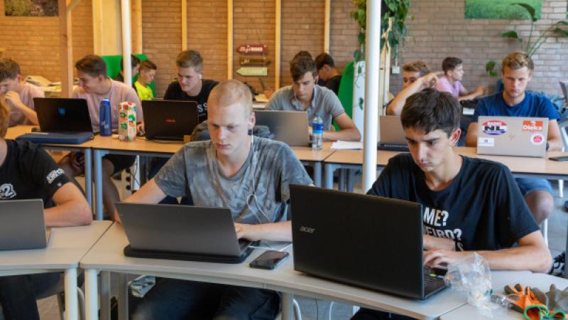 Scholieren zitten met laptop in klaslokaal
