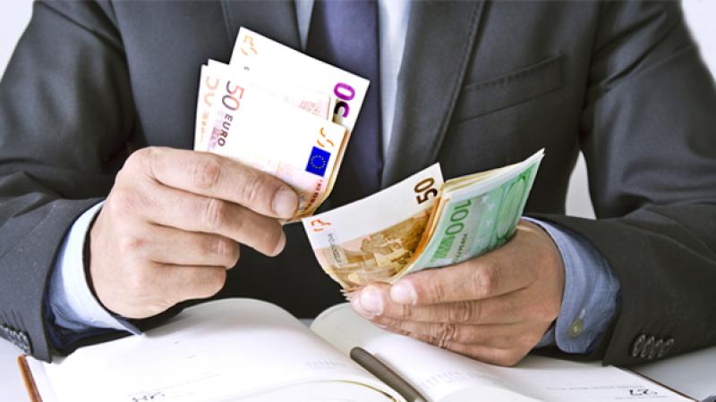 Een meneer houd verschillende briefjes met geld in zijn handen