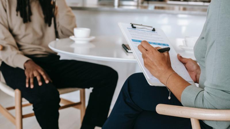 man en vrouw in gesprek, vrouw maakt notities