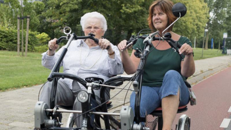 Twee vrouwen fietsen samen op een fietspad