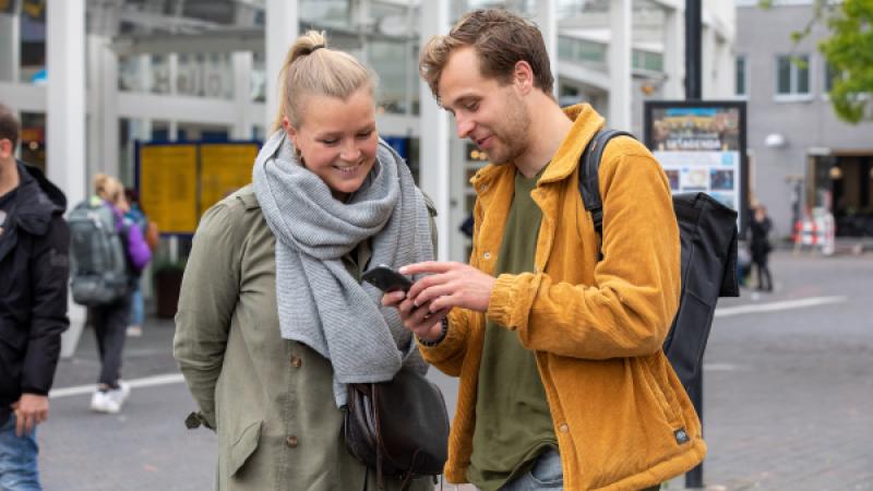 Jongen laat mobiel aan meisje zien