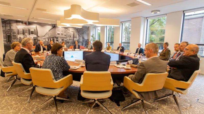 VNG-commissie aan een ovale tafel in een vergaderzaal