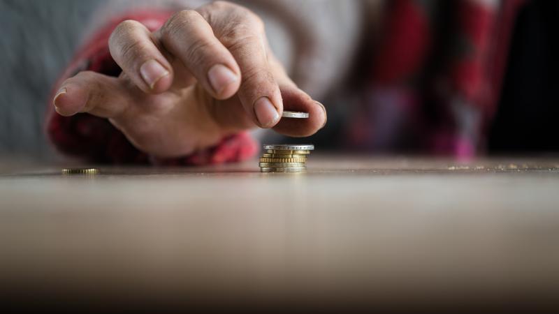 Mannenhand die munten opstapelt