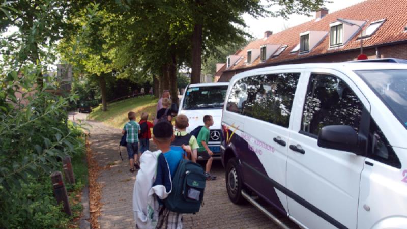 Kinderen staan klaar om in bus leerlingenvervoer te stappen