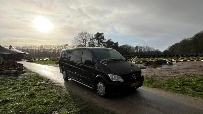 Lijkwagen rijdt de islamitische begraafplaats in Arnhem op, aan de rechterkant zijn graven zichtbaar