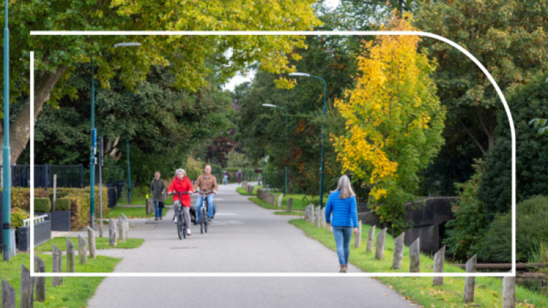 Mensen wandelen en fietsen in een groene omgeving