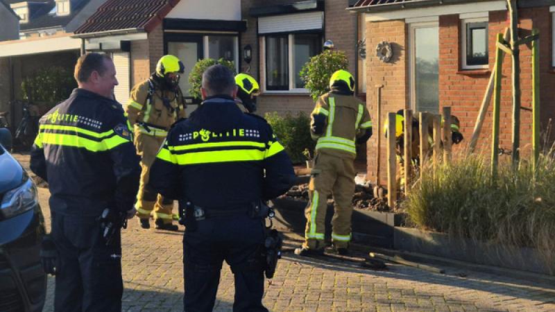 politie en brandweermannen (op de rug gezien) bekijken de gevolgen van een explosie bij een woning