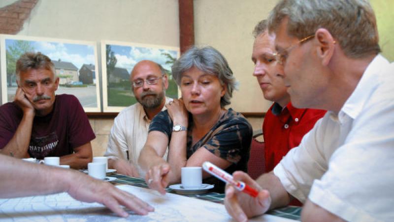groep mensen in discussie bij een landkaart