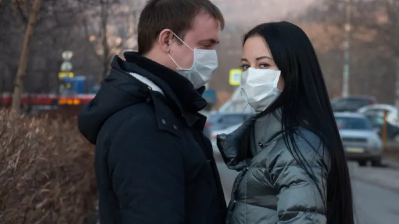 Man en vrouw op straat met mondkapjes