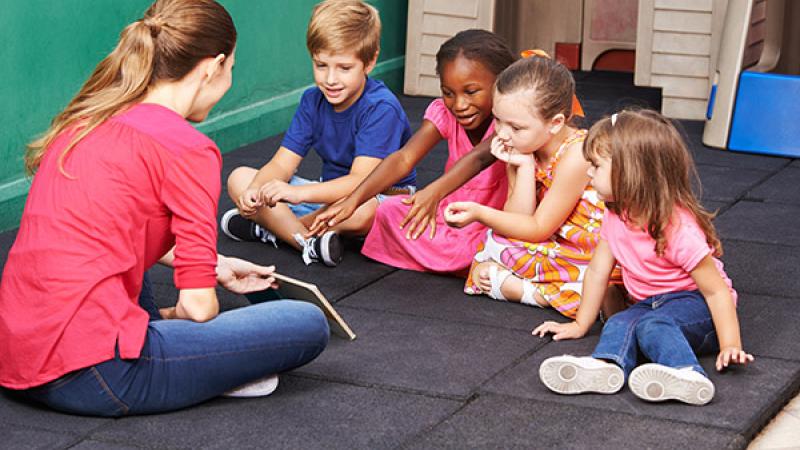 Kinderen met juf en boek