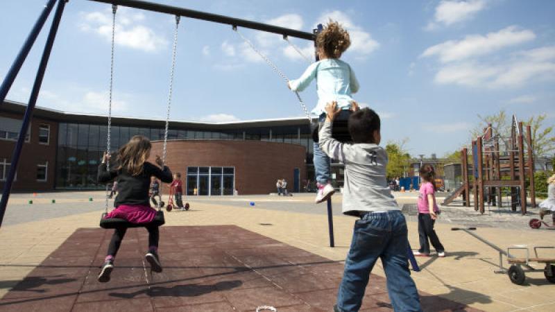 Kinderen schommelen op het schoolplein