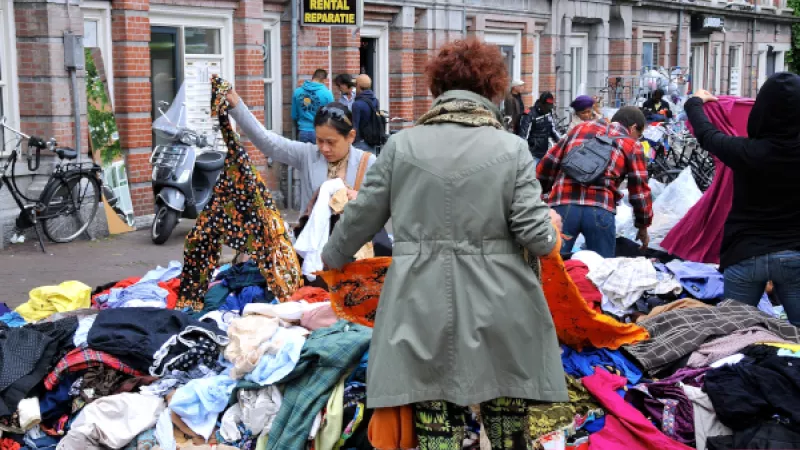 Mensen zoeken kleding uit op een markt