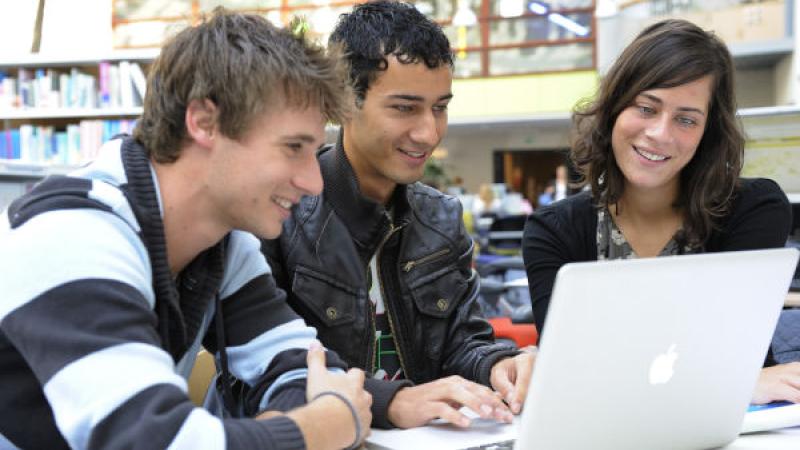 3 jongeren achter laptop