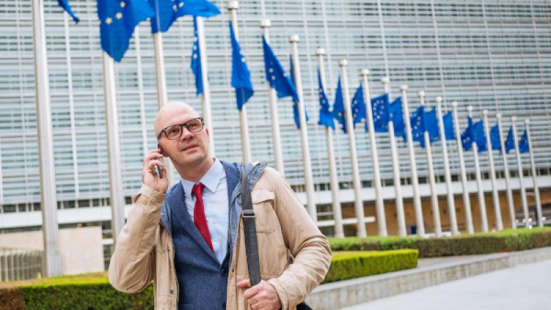 Man die langs vlaggenstokken met EU-vlag loopt