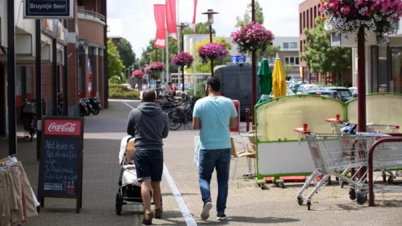winkelende mannen in de zomer achter kinderwagen