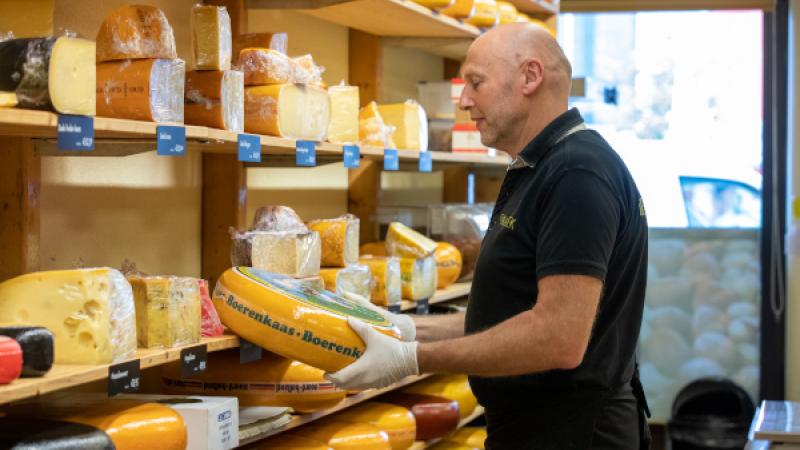 Medewerker met kaas in winkel