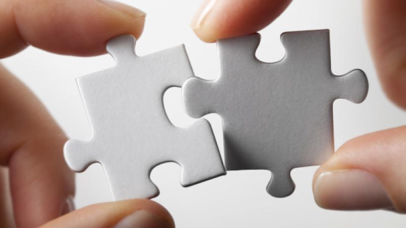 Close-up van 2 puzzelstukjes die in elkaar worden gepast