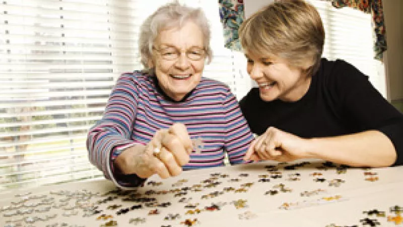 oudere en jongere vrouw maken een legpuzzle