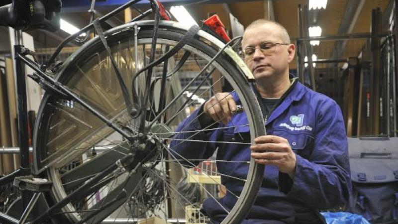 man die werkt aan een fietswiel