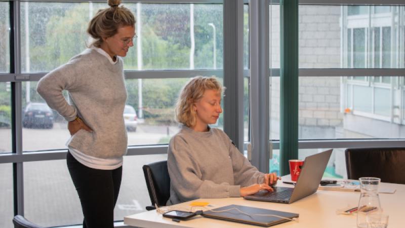 twee vrouwen achter een laptop aan het werk op kantoor