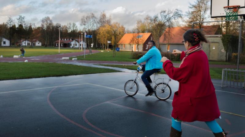 vrijwilliger leert asielzoeker fietsen