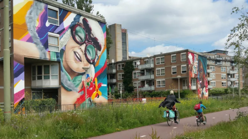 flats met muurschildering en voorbijrijdende fietsers