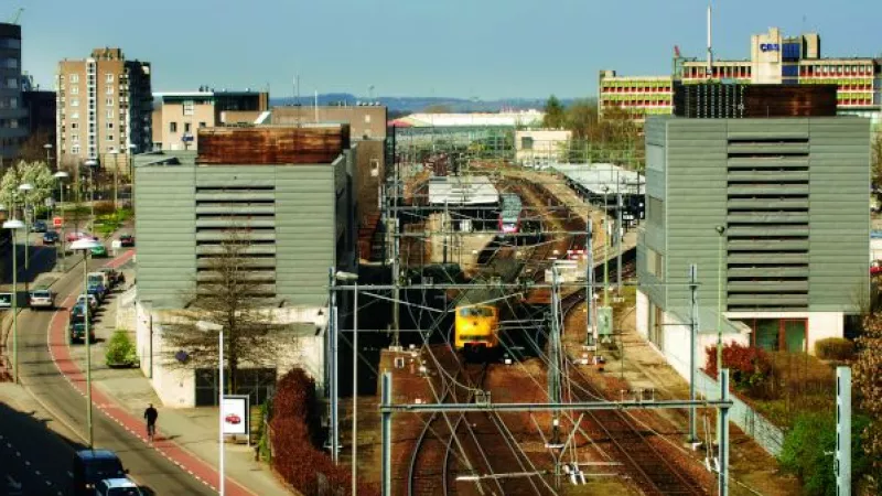 Overzichtsfoto met een trein die tussen kantoorgebouwen door rijdt