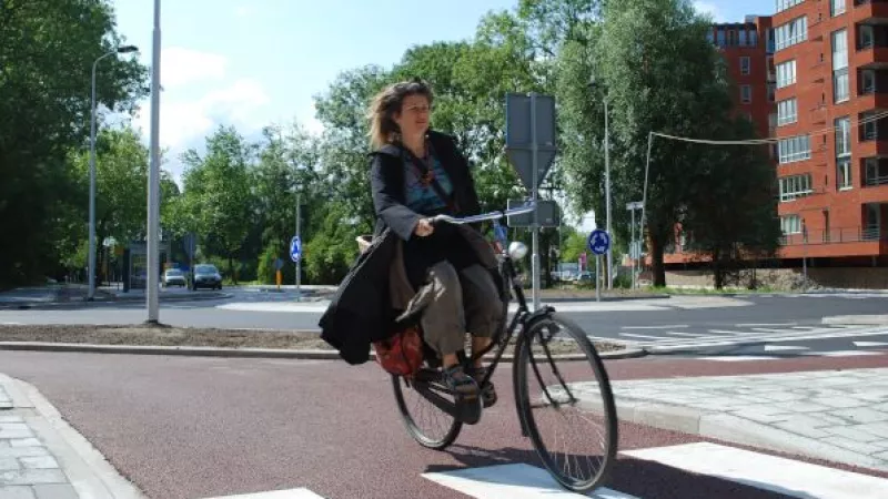 vrouw rijdt op fiets op fietspad in de stad