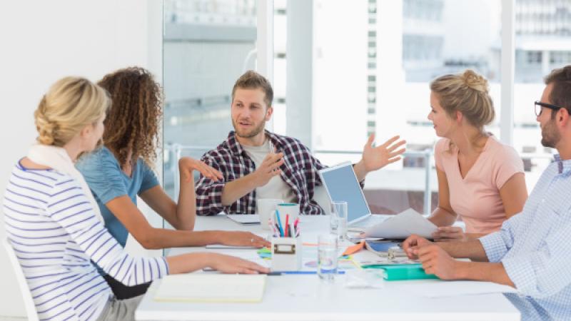 Een aantal mensen zitten samen aan tafel en overleggen met elkaar