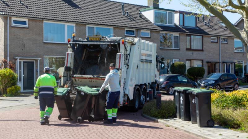 2 vuilnismannen legen containers in een vuilniswagen