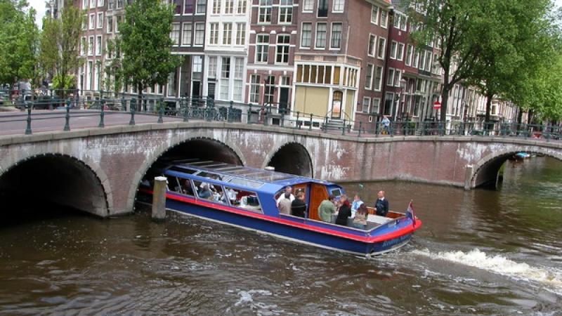 rondvaartboot vaart onder brug in Amsterdamse gracht
