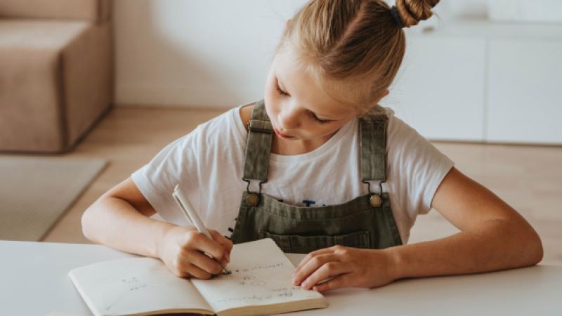 Meisje schrijft in notitieboekje