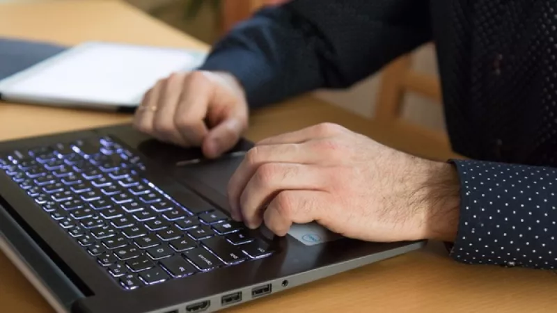 Close-up van 2 handen op het toetsenbord van een laptop
