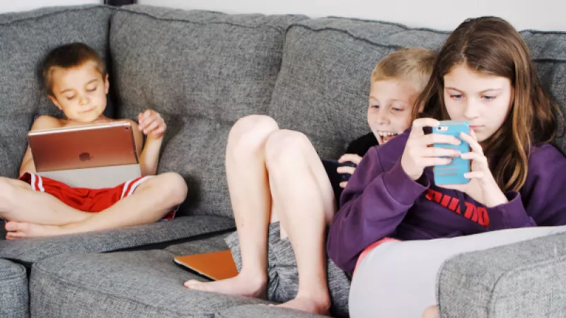 Jongeren met laptop en smartphone op de bank