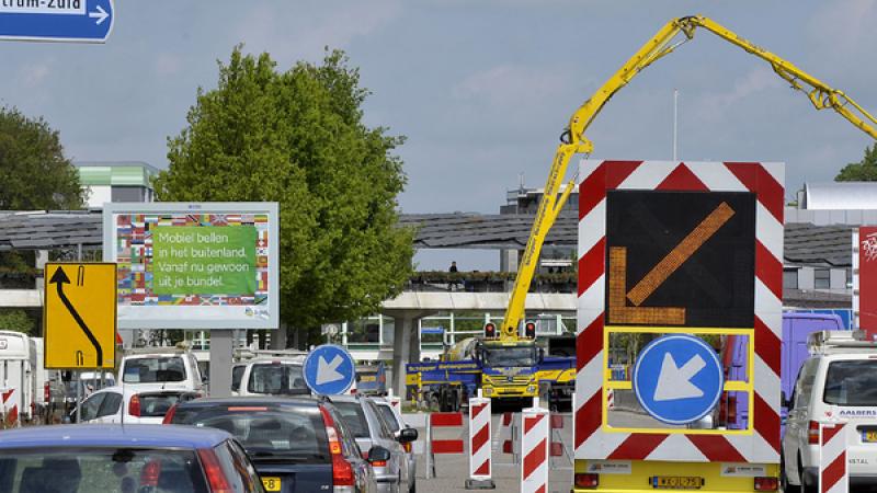 Auto's rijden langs een stuk weg dat is afgezet voor werkzaamheden