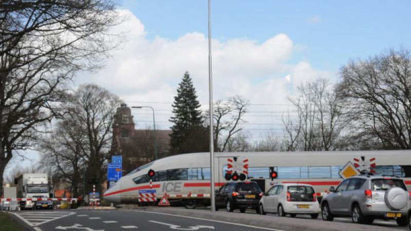 Spoorovergang met trein en wachtende auto's 