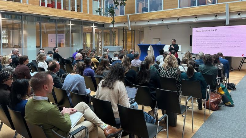 Sfeerbeeld van het publiek tijdens de atriumlezing over arbeidsmigranten